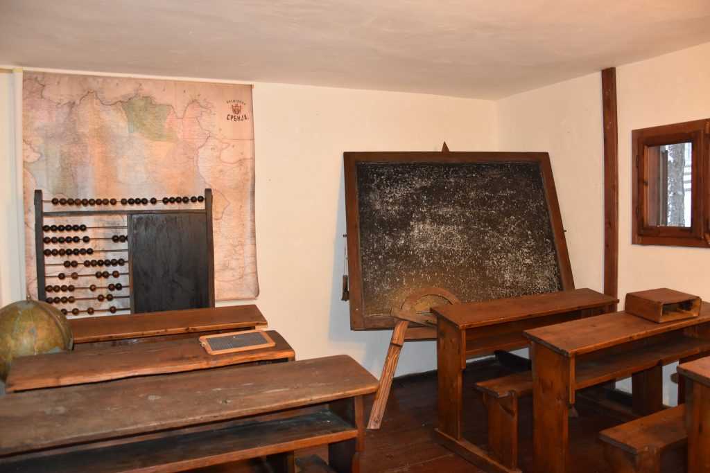 Unutrasnjost stare ucionice u muzeju Sirogojno sa drvenim klupama tablom i skamijama