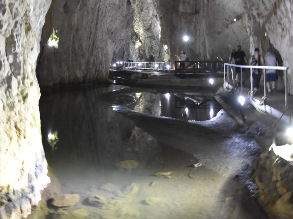 Uredjene pesacke staze i stepeniste unutar Stopica pecine sa pogledom na visoke pecinske zidove i osvetljene kanale