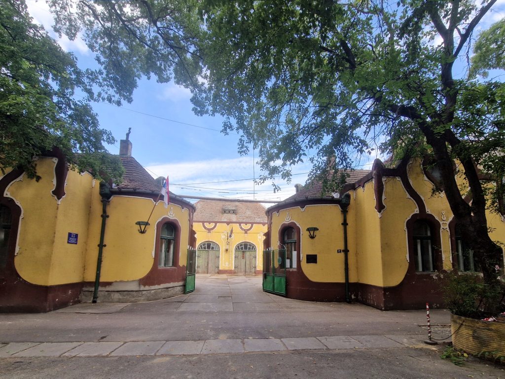 Fasada vatrogasnog doma u Senti sa prepoznatljivim žutim tornjem i dekorativnim elementima pod vedrim nebom