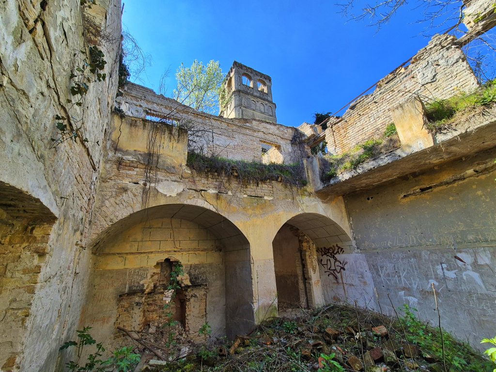 Rusevine centralnog hola i prijemnog salona dvorca Fernbah na Baba Pusti sa pogledom na toranj kroz uruseni krov
