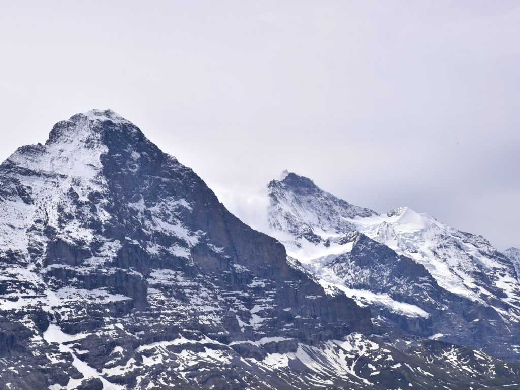 Dva planinska vrha Eiger i Mench pod oblacnim nebom