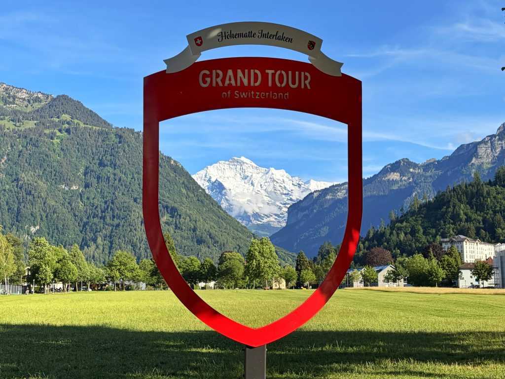 Znak Grand Tour of Switzerland u Interlakenu sa pogledom na vrh Jungfrau u okviru
