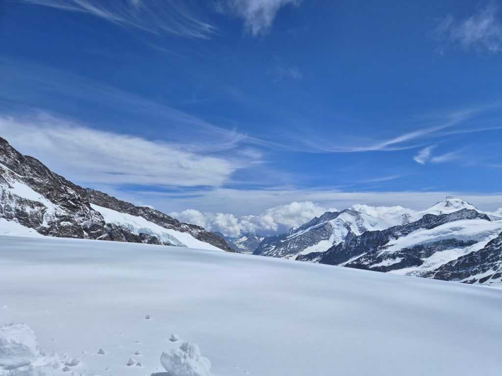 Sneg i plavo nebo na Jungfraujoch-u sa tragovima u snegu na prvom planu