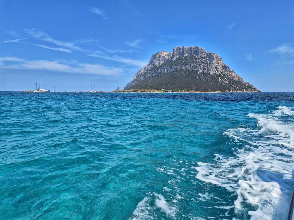 Monumentalna stena ostrva Tavolara u Sardiniji okruzena tirkiznim morem snimljena sa broda u pokretu