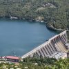 Pogled sa visine na branu hidroelektrane i Perucacko jezero okruzeno zelenim sumama