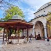 Sadrvan u dvoristu Gazi Husrev-begove dzamije u Sarajevu sa vernicima i turistima na suncanom danu