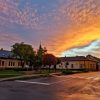 Pogled na ugao Glavnog trga i Tiskog keja u Senti tokom zalaska sunca sa dramatičnim narandžastim oblacima iznad gradskih kuća