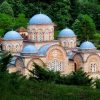 Manastir Celije kod Valjeva sa karakteristicnim plavim kupolama i fasadom od cigle okruzen gustim zelenilom i sumom