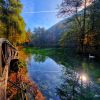 Prirodni spomenik Vrelo Bosne u Sarajevu sa labudovima na jezeru i jesenjim liscem koje okruzuje drveni most